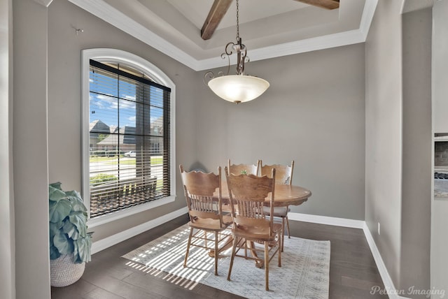 dining area featuring healthy amount of natural light, wood finished floors, a tray ceiling, baseboards, and ornamental molding