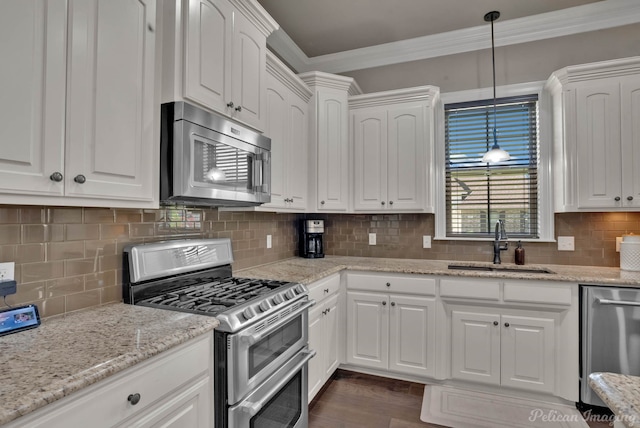 kitchen featuring stainless steel appliances, ornamental molding, a sink, white cabinetry, and backsplash