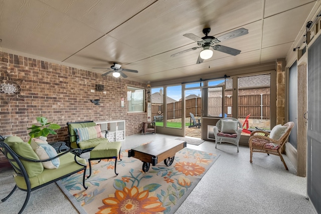 sunroom featuring an outdoor hangout area, a ceiling fan, and brick wall