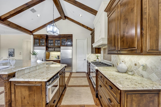kitchen with high quality appliances, a sink, beamed ceiling, decorative backsplash, and decorative light fixtures
