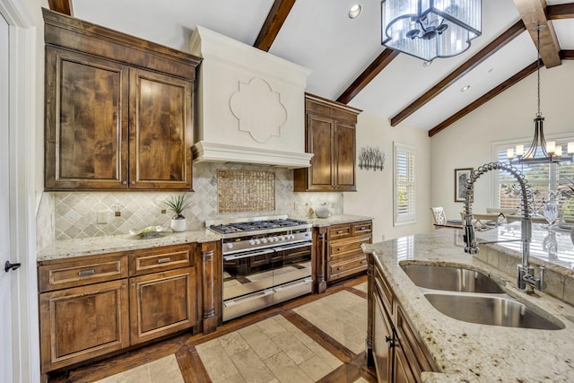 kitchen featuring range with two ovens, a chandelier, a sink, decorative light fixtures, and inlaid floor details
