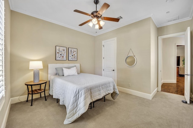carpeted bedroom with baseboards, ornamental molding, and ceiling fan