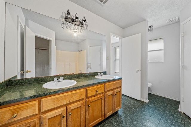 4627 Lexington St, Bellmead, TX 76705 - full bath with double vanity, tile patterned floors, toilet, and a textured ceiling