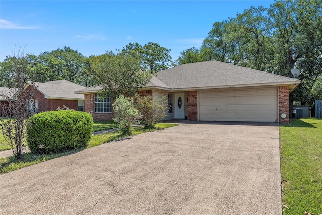 4627 Lexington St, Bellmead, TX 76705 - view of front of house with concrete driveway, a garage, a front lawn, brick siding, and central AC