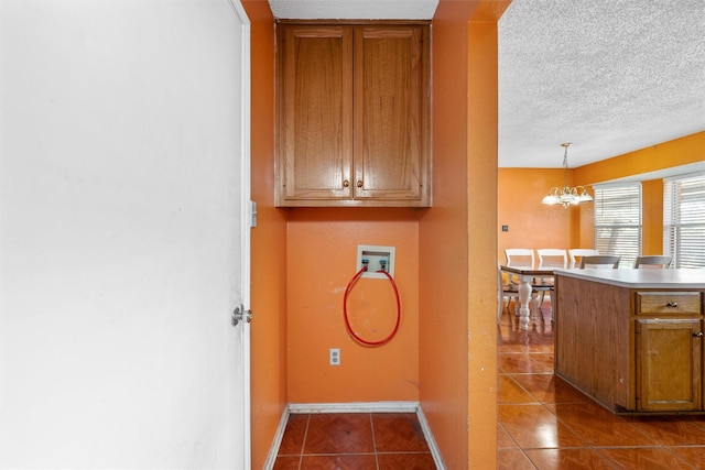 4627 Lexington St, Bellmead, TX 76705 - washroom with hookup for a washing machine, a chandelier, dark tile patterned flooring, a textured ceiling, and baseboards