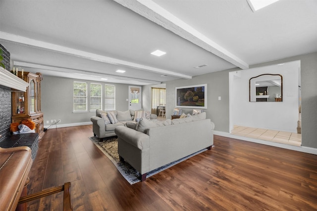 living area with wood finished floors, beamed ceiling, and baseboards