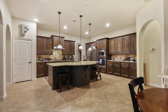 4213 Autumn Path Rd, Denton, TX 76208 - kitchen with stainless steel appliances, arched walkways, backsplash, dark brown cabinetry, and recessed lighting