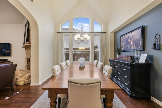 4213 Autumn Path Rd, Denton, TX 76208 - dining area featuring a chandelier, dark wood finished floors, arched walkways, baseboards, and vaulted ceiling