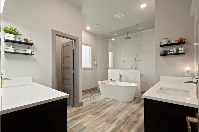 1595 Bledsoe Rd, Gunter, TX 75058 - bathroom featuring double vanity, walk in shower, wood finished floors, a soaking tub, and recessed lighting