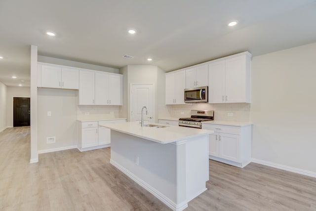 506 Stagg St, Mckinney, TX 75069 - kitchen with stainless steel appliances, a sink, a kitchen island with sink, light wood finished floors, and recessed lighting