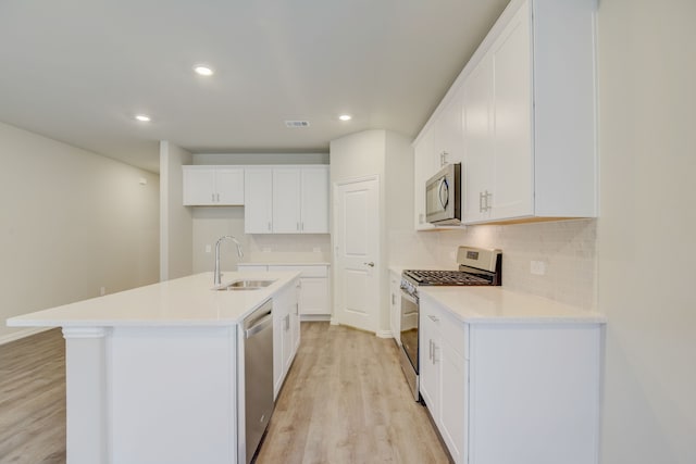 506 Stagg St, Mckinney, TX 75069 - kitchen featuring stainless steel appliances, a sink, light wood-style flooring, decorative backsplash, and a center island with sink