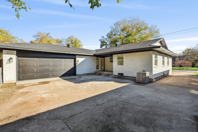single story home with brick siding, driveway, a garage, and cooling unit