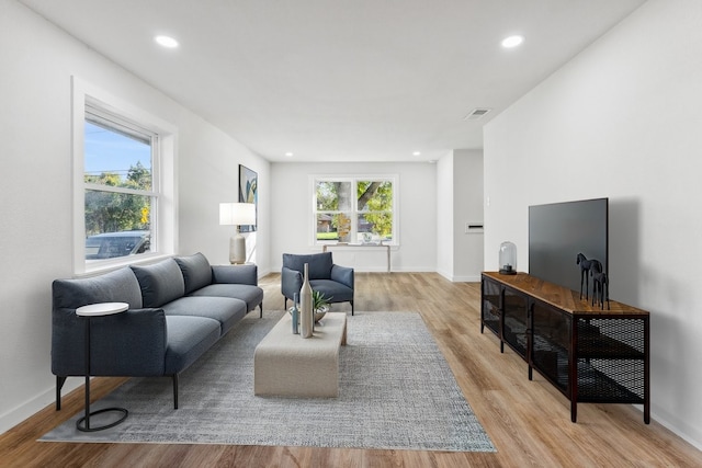 living area featuring light wood finished floors, recessed lighting, and baseboards