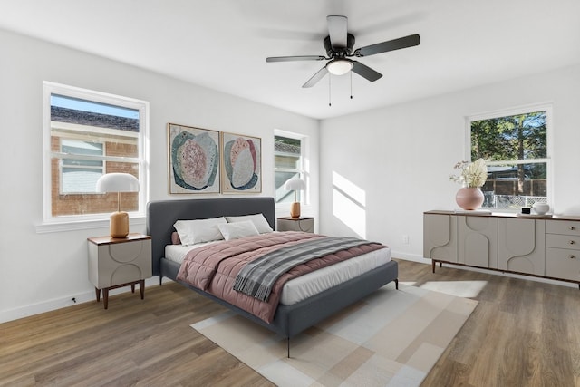 bedroom with wood finished floors, baseboards, and ceiling fan