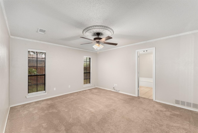 carpeted empty room with a ceiling fan, ornamental molding, a textured ceiling, and baseboards