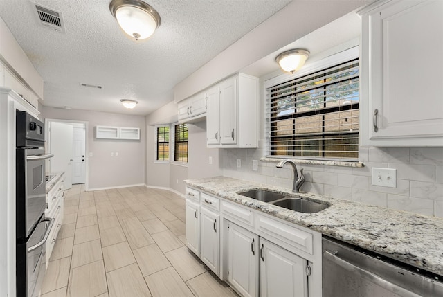 kitchen featuring a sink, stainless steel appliances, backsplash, baseboards, and white cabinets