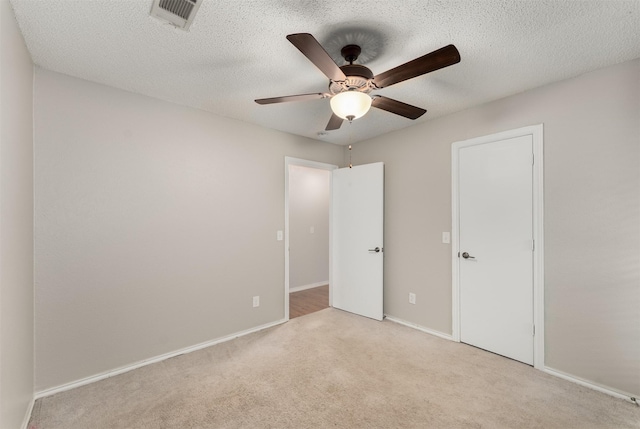 unfurnished bedroom featuring carpet flooring, baseboards, a ceiling fan, and a textured ceiling