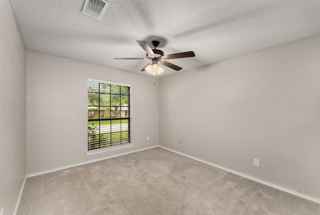 spare room with ceiling fan, carpet floors, baseboards, and a textured ceiling