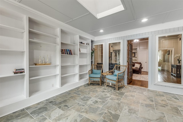 living area with crown molding, built in features, stone finish flooring, and recessed lighting