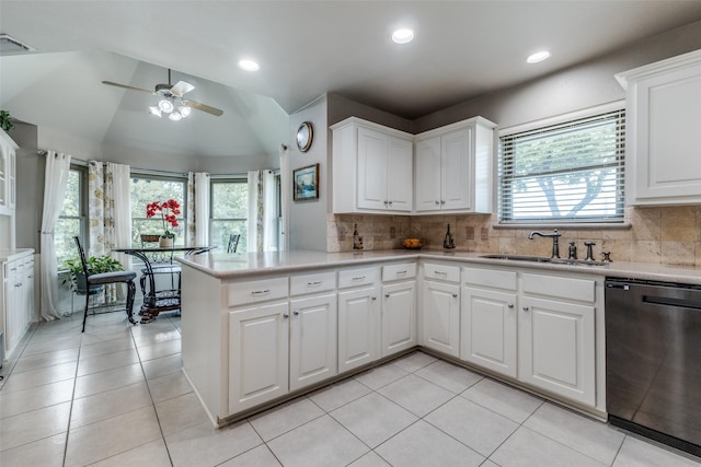 kitchen featuring dishwashing machine, a sink, plenty of natural light, light countertops, and vaulted ceiling
