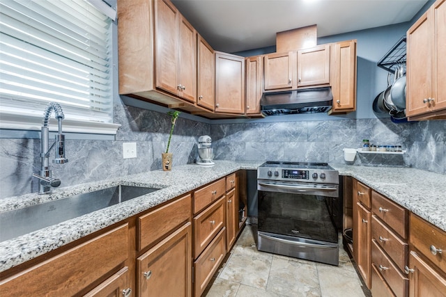 kitchen featuring stainless steel range with electric stovetop, under cabinet range hood, a sink, and backsplash