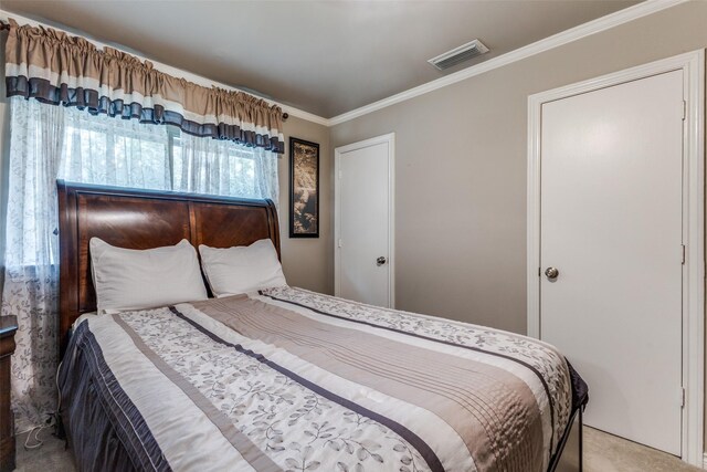 bedroom featuring ornamental molding and carpet floors