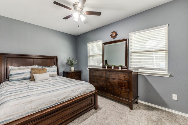 bedroom with light colored carpet, baseboards, and ceiling fan