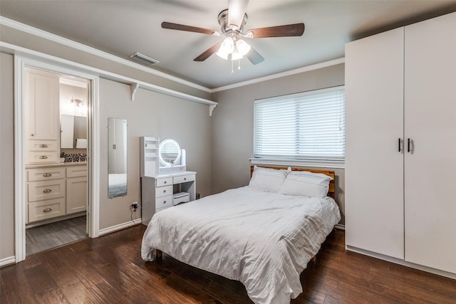 bedroom with dark wood-style flooring, ornamental molding, connected bathroom, a ceiling fan, and baseboards