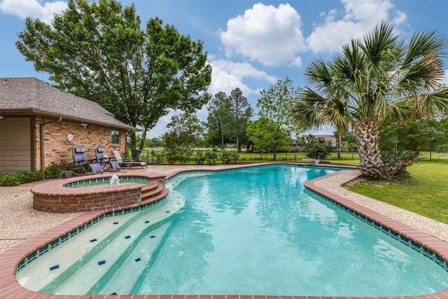 view of swimming pool featuring fence and a pool with connected hot tub