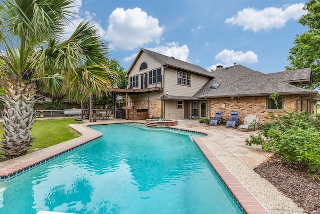 view of swimming pool with a patio, fence, and a pool with connected hot tub
