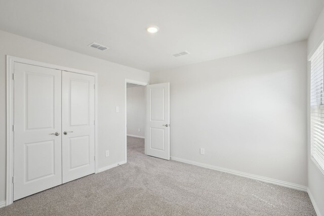 unfurnished bedroom featuring carpet floors, baseboards, a closet, and recessed lighting