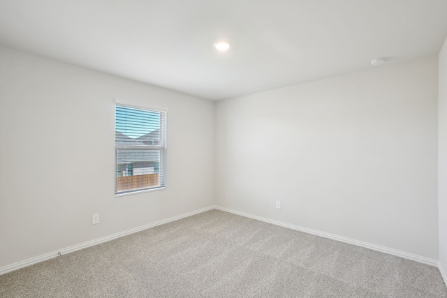 spare room featuring light colored carpet, baseboards, and recessed lighting