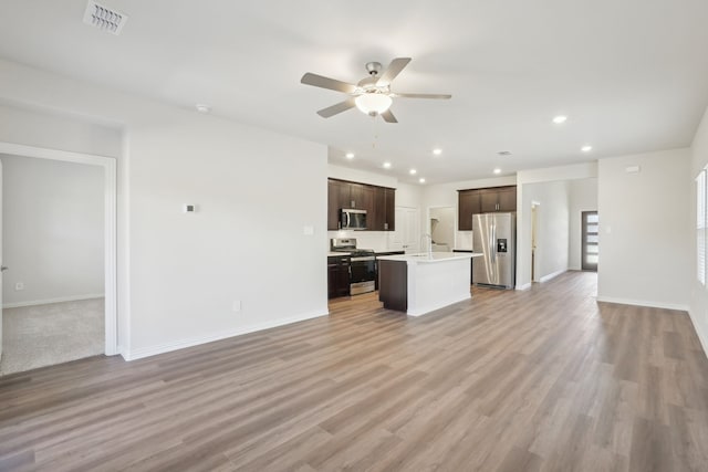 unfurnished living room featuring ceiling fan, recessed lighting, light wood finished floors, baseboards, and a sink