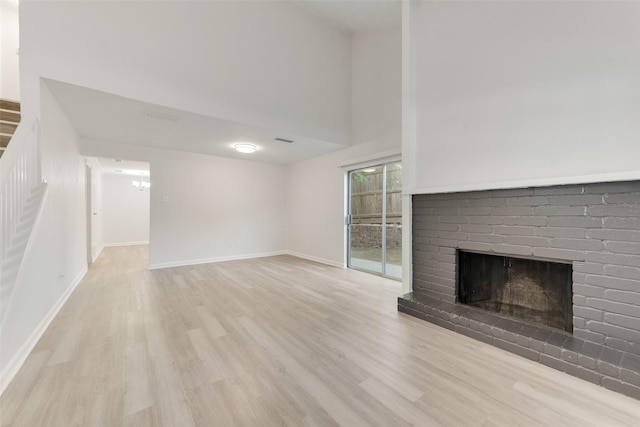 1112 Terrace Trl, Carrollton, TX 75006 - unfurnished living room with wood finished floors, a brick fireplace, baseboards, and a high ceiling