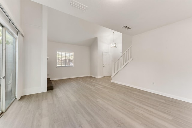 1112 Terrace Trl, Carrollton, TX 75006 - unfurnished living room featuring light wood-style floors, stairway, lofted ceiling, and baseboards