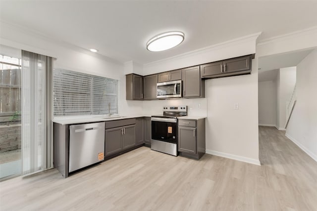 1112 Terrace Trl, Carrollton, TX 75006 - kitchen with appliances with stainless steel finishes, light wood-style flooring, crown molding, a sink, and light countertops