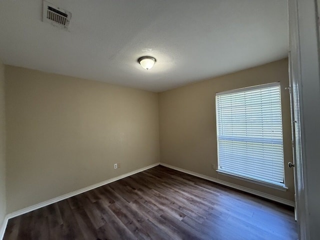 unfurnished room with dark wood-style flooring and baseboards