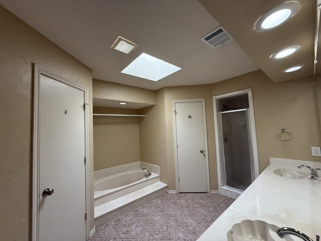full bath featuring a skylight, a shower stall, a bath, double vanity, and baseboards