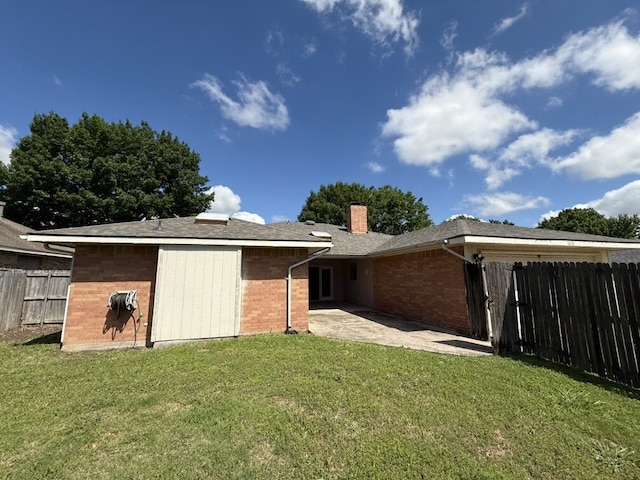 rear view of house with a chimney, a patio, and brick siding