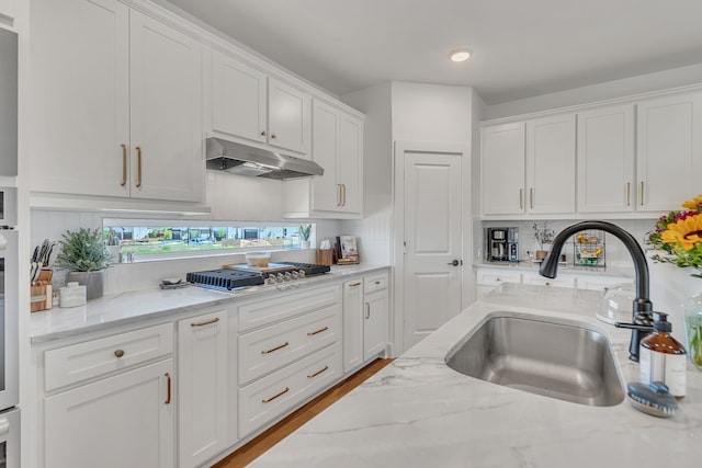 601 Wilderness Point Ln, Anna, TX 75409 - kitchen featuring under cabinet range hood, a sink, white cabinets, light stone counters, and recessed lighting