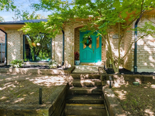 property entrance featuring brick siding