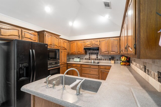 kitchen with black appliances, under cabinet range hood, vaulted ceiling, tasteful backsplash, and brown cabinetry
