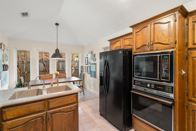 kitchen with black appliances, a sink, brown cabinets, decorative light fixtures, and light tile patterned floors