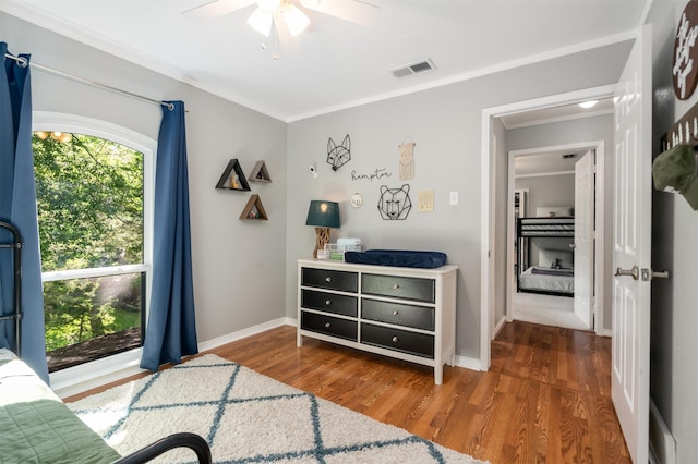 bedroom featuring wood finished floors, ornamental molding, baseboards, and ceiling fan