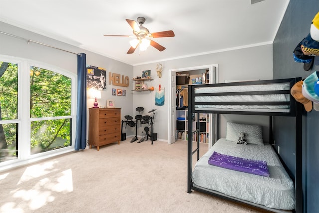 carpeted bedroom featuring ceiling fan and ornamental molding