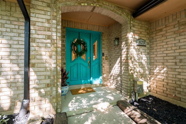 view of exterior entry featuring brick siding