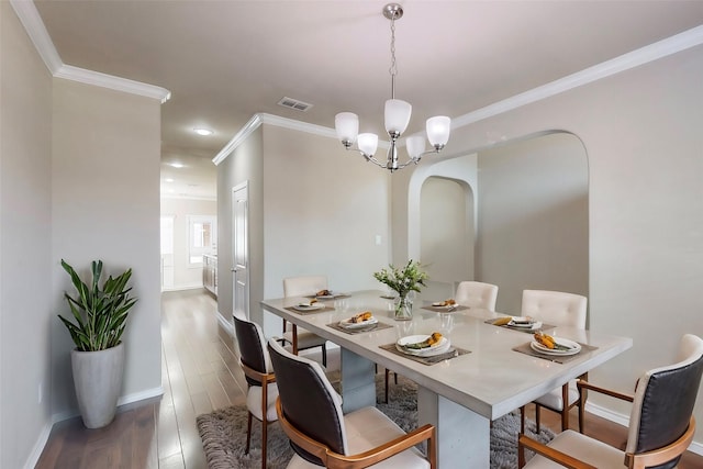 13013 Palancar Dr, Fort Worth, TX 76244 - dining room featuring ornamental molding, baseboards, a chandelier, wood finished floors, and arched walkways