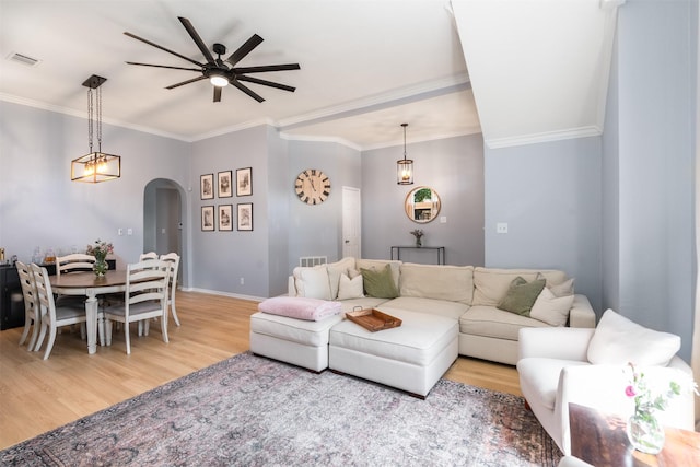 2038 Frontier Trl, Lewisville, TX 75067 - living area featuring arched walkways, ceiling fan, light wood-type flooring, crown molding, and baseboards