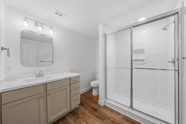 1720 Bagby Ave, Waco, TX 76706 - bathroom featuring wood finished floors, toilet, vanity, and a stall shower