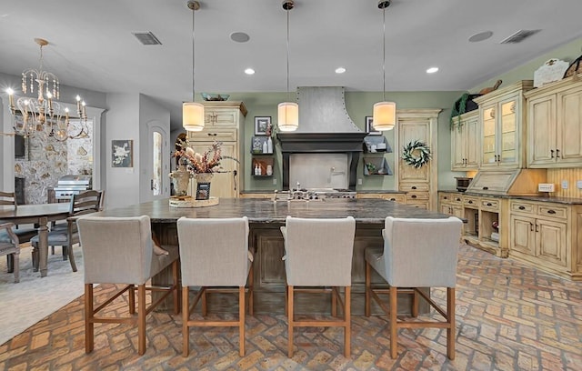 8416 Spicewood Springs Rd, Waco, TX 76633 - kitchen with cream cabinets, brick floors, premium range hood, decorative backsplash, and recessed lighting
